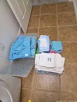 All cloths stacked with clear bin to side