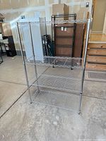 Full view of chrome wire shelving rack showing three installed shelves and vertical posts