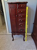 Full front view showing drawers, door, legs and tape for height