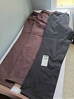 Black and brown pants laid flat full view
