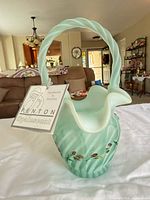 Front view of pale green opalescent basket with tag attached