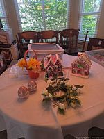 Overview of two ceramic houses, two glitter eggs, faux floral bucket and wreath