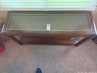 Top view of console table showing glass inset, brass trim, lot tag
