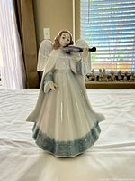 Front view of Lladró angel figurine showing robe, wings, violin