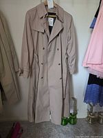 Front view of full trench coat on hanger showing color, length and belt