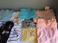 Overview of ten folded tops displaying variety of colors and designs