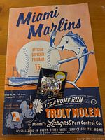 Front cover of Miami Marlins program with World Series pin placed on top