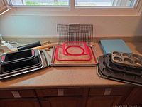 Full lot showing baking sheets, pans, rack, mats, rolling pins on countertop