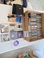 Overview of open Motorola box packed with stacked jewel-case CDs, loose discs, and carrying wallet