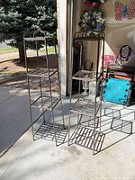 Pair of tall narrow metal etageres with four shelves each