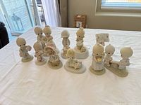 Group shot of all 11 Precious Moments figurines on table