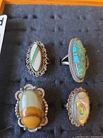 Front view of four sterling silver rings with various stones