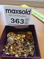 Overall contents of jewelry lot inside small purple box