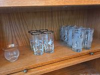 All thirteen glass pieces on wooden shelf