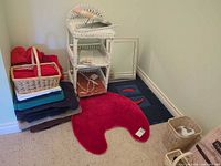 Wicker shelf, towels, rugs, baskets, mirror in corner
