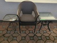 Armchair centered with two side tables on patio surface