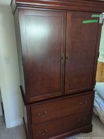 Front view of armoire showing doors and drawers