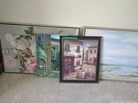 Four framed artworks leaning against wall