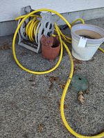 Hose coiled on reel beside two planters