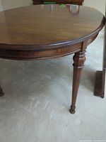 Full view of oval dining table showing legs and finish