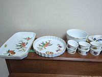 Full set on display: platter, tart dish, casserole with lid, six ramekins