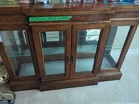 Front view of wood buffet with glass doors and shelves