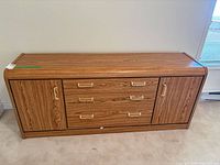 Front view of oak veneer sideboard showing three drawers and two cabinet doors