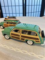Two diecast woodie station wagons side by side