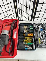 Milwaukee reciprocating saw, socket set, screwdriver kit displayed on table