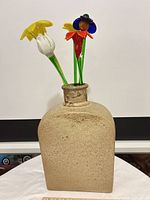 Stoneware vase with three of five glass flowers visible
