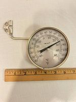 Front view showing dial, scale markings and 4" ruler for size reference