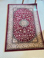 Full view of burgundy oriental floral rug on carpet
