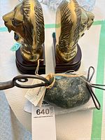 top view of two brass lion head bookends and stone with iron accent