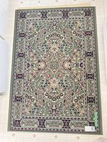 Full view of green Oriental pattern rug on tiled floor