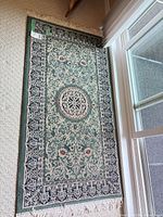 Full view of green oriental runner rug hanging