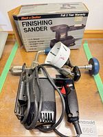 Finishing sander, drill, hole saw, brace, and sander box on table