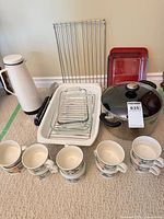 Complete lot showing mugs, glass bakeware, pot, roasting pan, red dish, racks, thermos