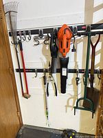 All five tools hanging on wall rack