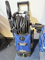 Front view showing Simoniz branding, 2000 PSI label, hose reel, overall condition