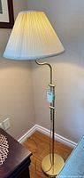Full view of brass floor lamp with shade