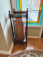 umbrella stand in corner with wicker insert and drip tray visible