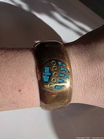 Bracelet worn on wrist showing bear paw turquoise inlay