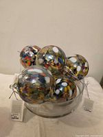 Cluster of multicolour blown glass spheres inside clear bowl