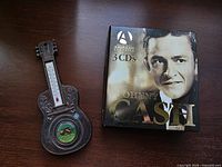 Johnny Cash 3-CD box set front cover beside guitar thermometer