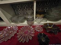shelved clear and carnival glass bowls, plates, ruffled pieces foreground