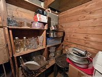 Shelving with assorted glass jars, crystal bowls, metal pans, plates and trays