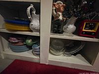 Overall view showing dinner plates, bowls, pitchers, figurine, glassware and snow globe
