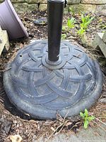 Full view of round metal umbrella base outdoors