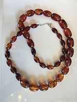 Full view of necklace laid flat showing bead sizes and clasp