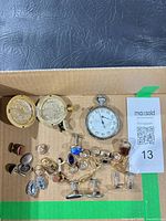 Overview of cufflinks, stopwatch, pocket watch in box